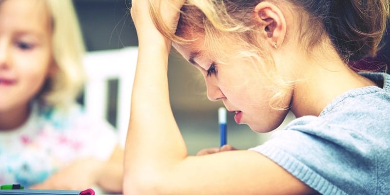 Meisje is aan het schrijven, ondersteund hoofd met hand. Buiten in de zomer