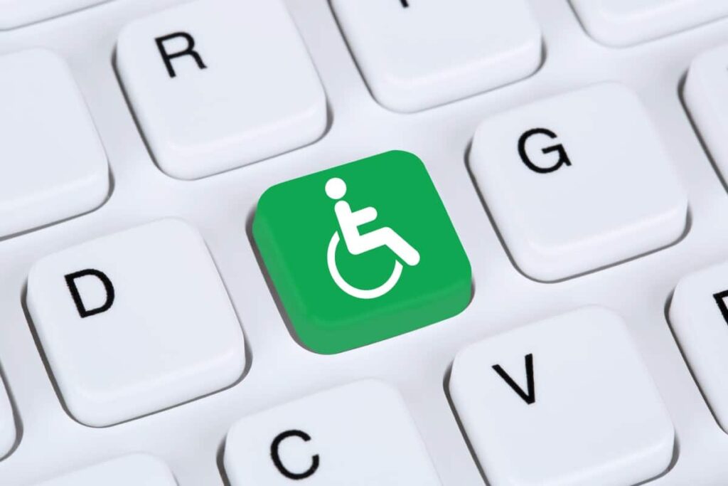 Een groene toetsenbordknop met een rolstoel-icoon beeldt digitale toegankelijkheid uit en staat tussen andere toetsenbordletters