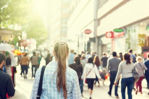 Mensen lopen door een winkelstraat, op de rug gezien
