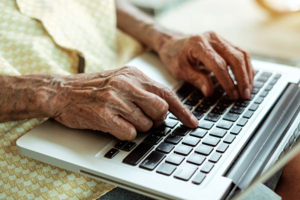Handen van een ouder iemand bedienen een laptop