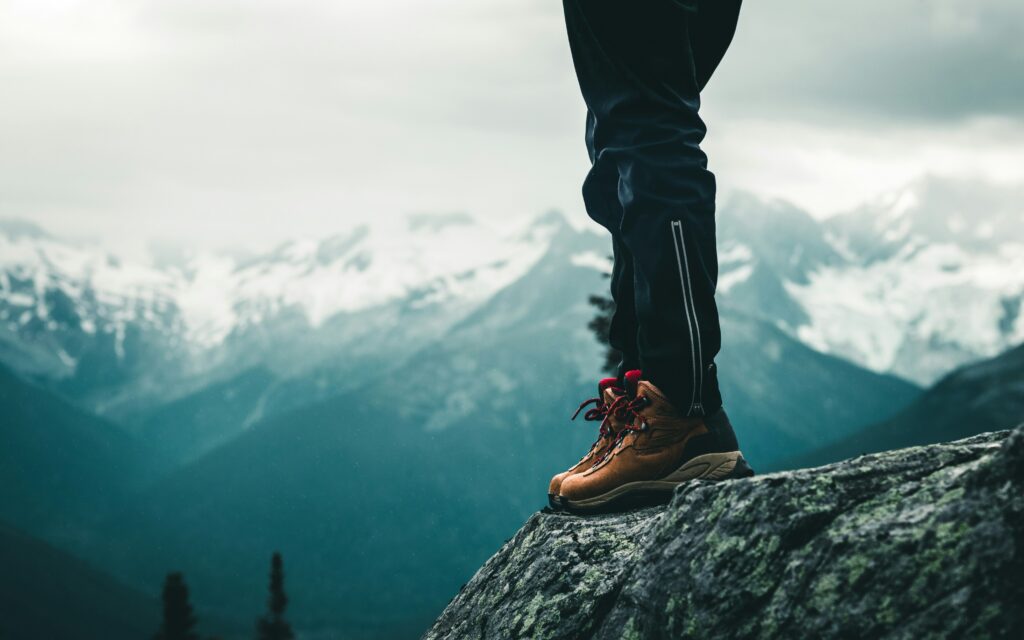 benen en berschoenen bovenop een klif